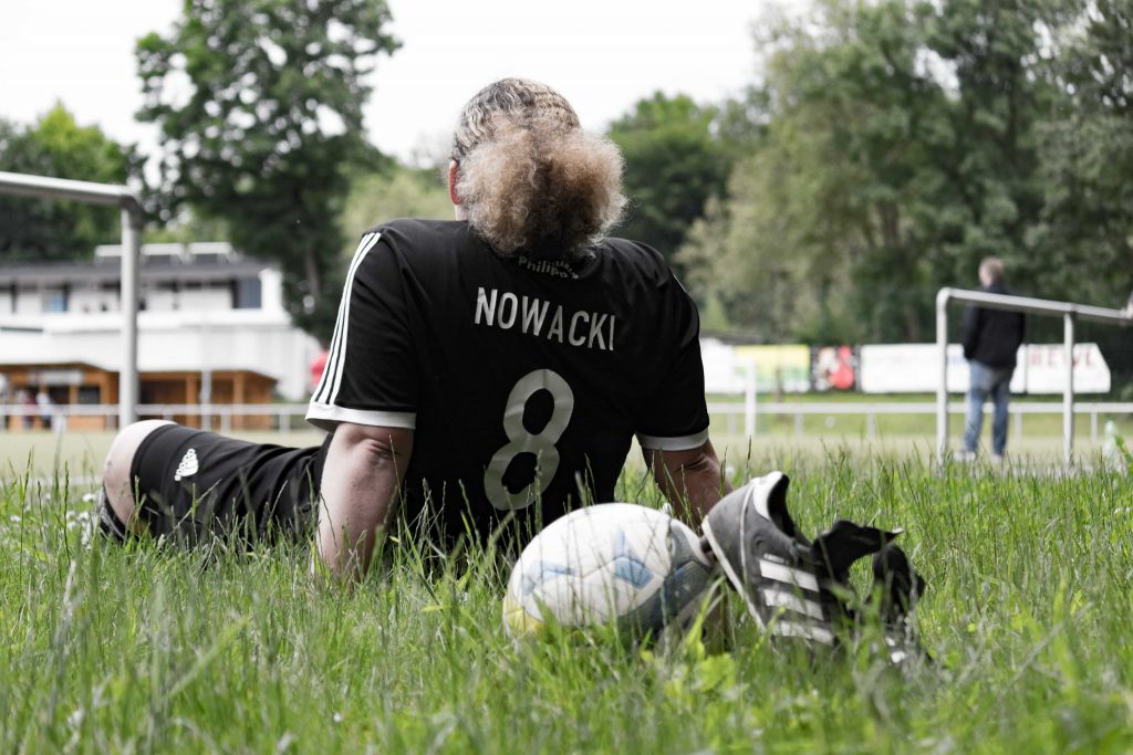 Sylwia Nowacki von hinten auf dem Rasen seitzend